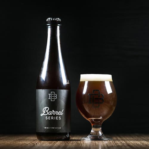Barrel aged bottle with a beer glass